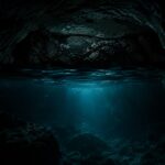 Vista de caverna subaquática com luz filtrada na água escura (Créditos: Adamy Gianinni)